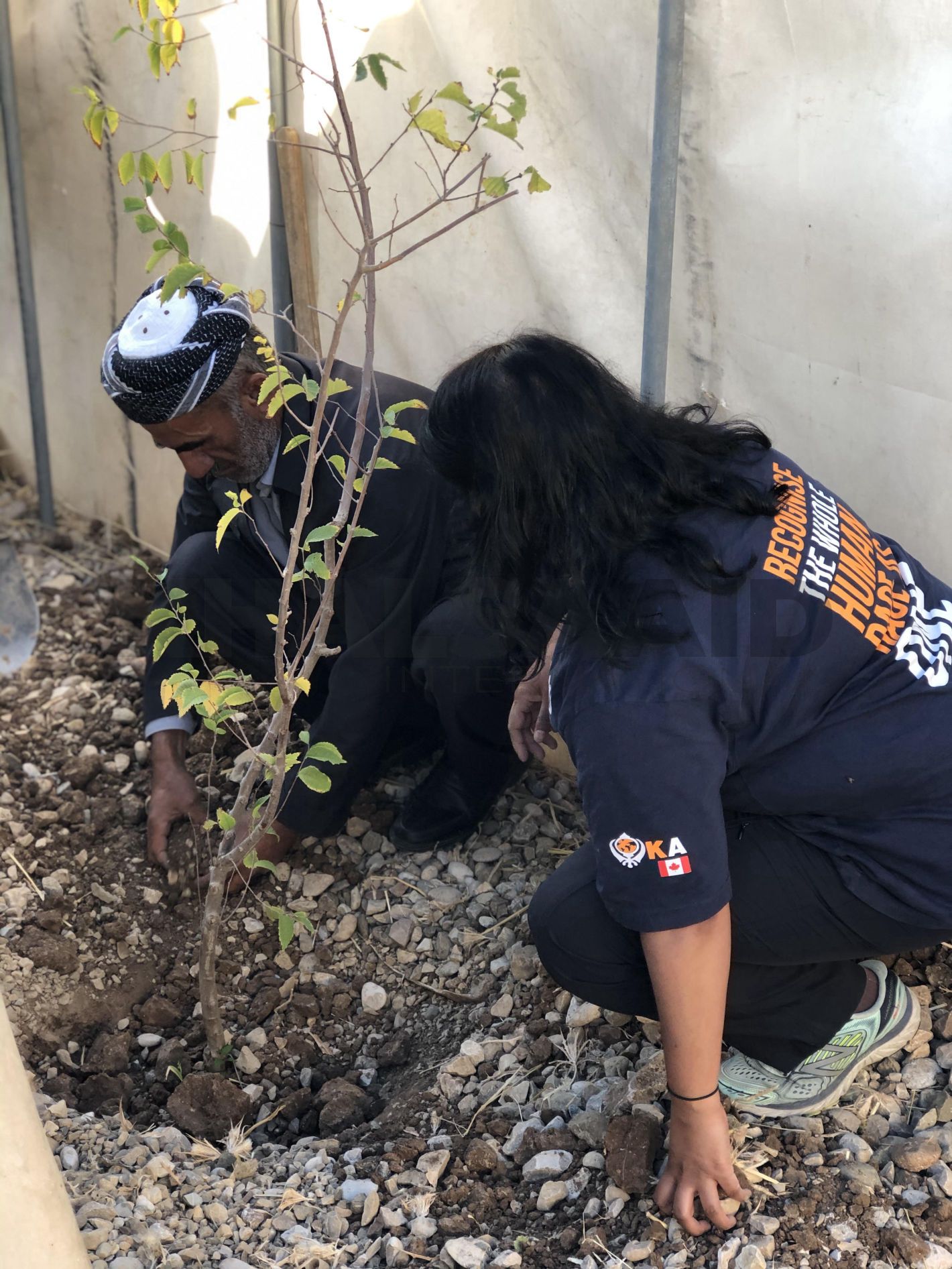 An elder shares his story of loss while planting a tree.