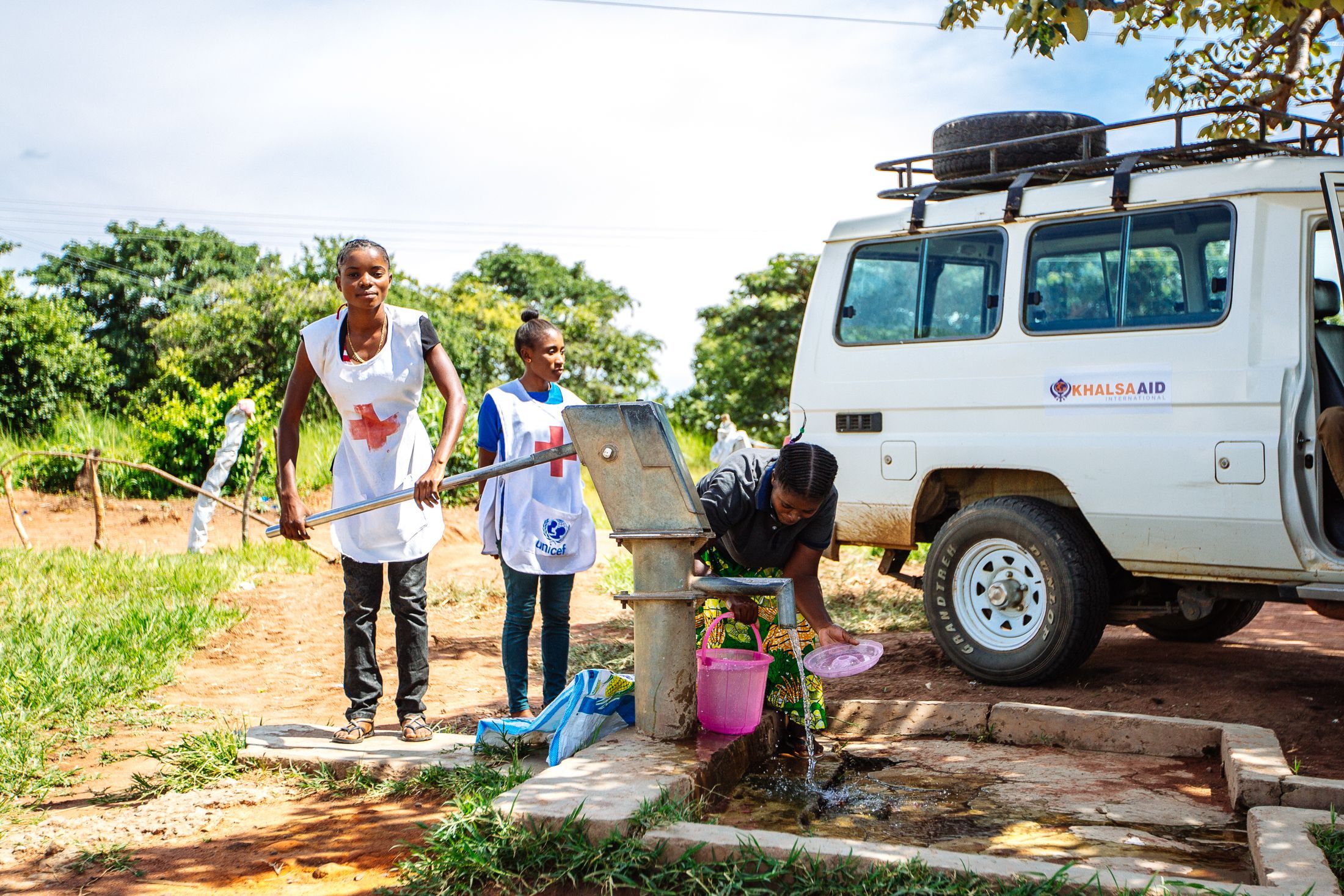 Two volunteers pumping water in Malawi.