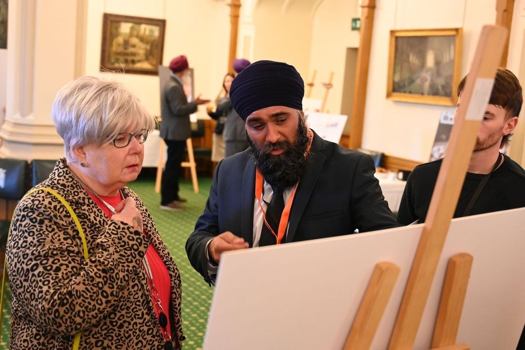 Chamkor Singh, volunteer of Khalsa Aid, showcasing our gallery to an attendee. 